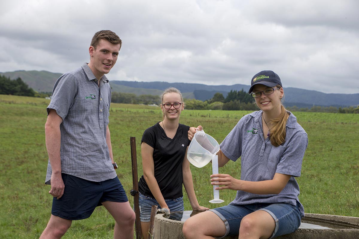 Three agriculture students doing testing on a farm
